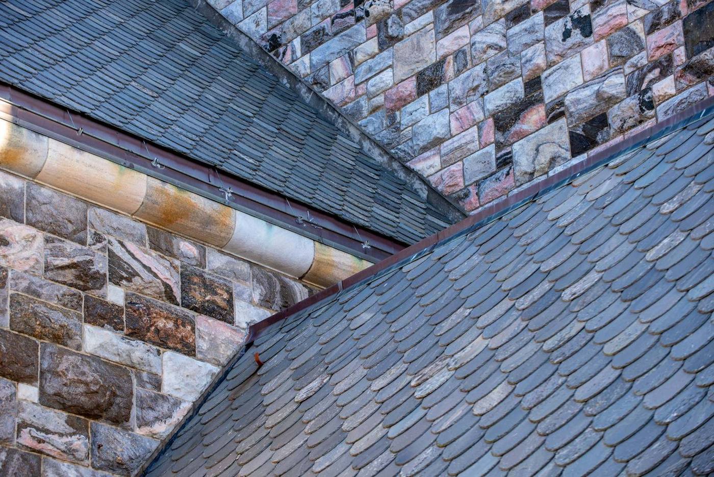Leien dak tegen een muur van natuursteen